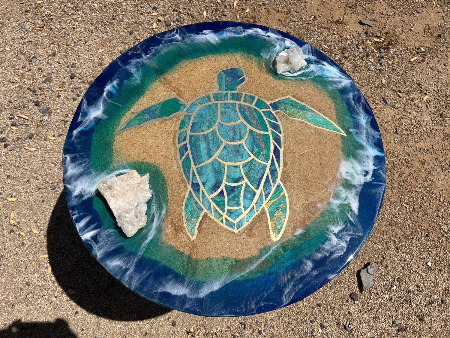 An ocean themed end table with real sand, quartz clusters, gold lining and wave effects